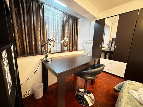 a bedroom with a desk with a lamp and a window at Fortress View Apartment in Timişoara