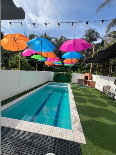 un groupe de parasols sur une clôture à côté d'une piscine dans l'établissement Cabaña salgar - la casa de la playa, à Puerto Salgar