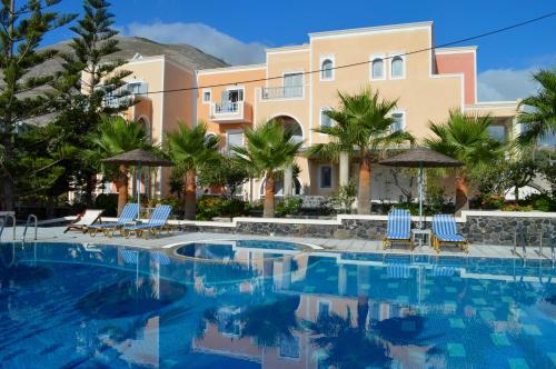 a resort with a swimming pool with chairs and umbrellas at Castro Hotel in Kamari