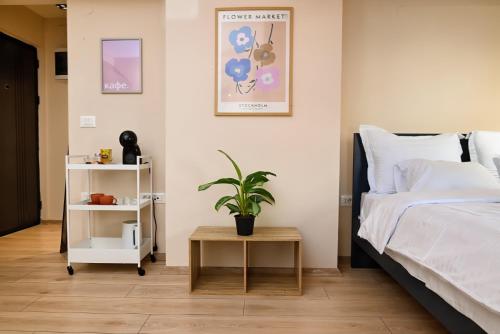 a bedroom with a bed and a plant on a table at Central Studio Apartments by Parkside Boutique in Skopje