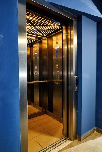 an elevator in a building with a blue wall at Central Studio Apartments by Parkside Boutique in Skopje