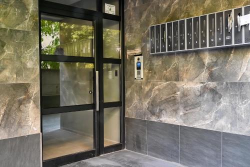 a glass door in front of a stone wall at Central Studio Apartments by Parkside Boutique in Skopje