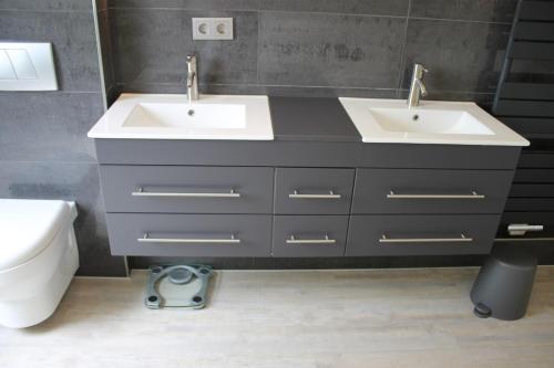 a bathroom with two sinks and a toilet at Foerde-Seasons in Eckernförde