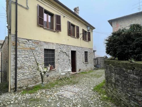 a stone house with windows and a stone wall at Comfortable apartment in Castell'Arquato of 80 m² in CastellʼArquato