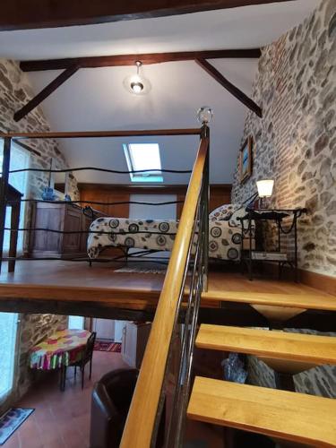 a room with a loft with a bed and stairs at La petite porcherie in Ladignac-le-Long