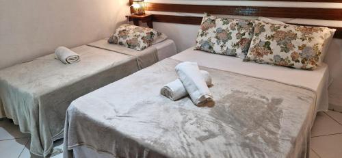 two beds with towels on them in a room at Cores de Boipeba in Ilha de Boipeba