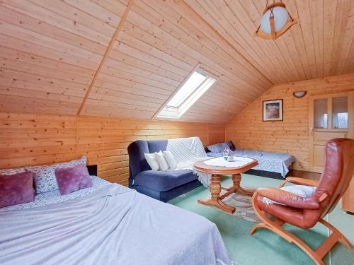 a room with a bed and a table and a couch at DOMKI U JOANNY in Przezmark