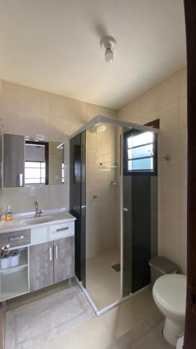 a bathroom with a shower and a sink and a toilet at amplo sobrado perto da praia in Florianópolis