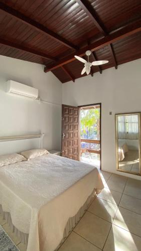 a bedroom with a bed and a ceiling fan at amplo sobrado perto da praia in Florianópolis