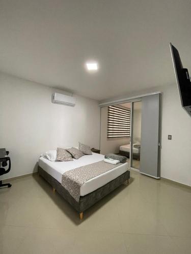 a bedroom with a bed and a large window at Casa Patio Bonito - Los Prados in Mocoa