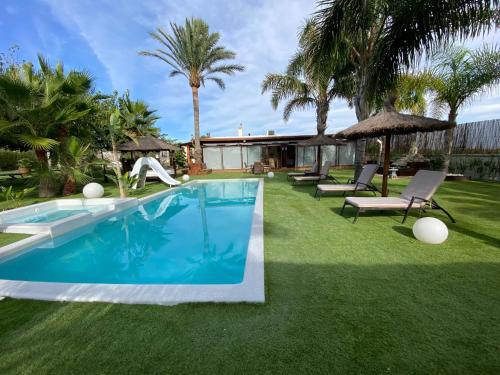 a backyard with a swimming pool and grass at Finca El Paraíso en Agost in Alicante