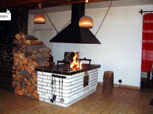 a fireplace in a room with a pile of wood at Hotel Tatranec in Tatranská Lomnica