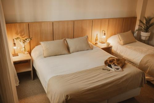 a hotel room with two beds and a dog on the bed at W&H Casa de Huéspedes in Mendoza