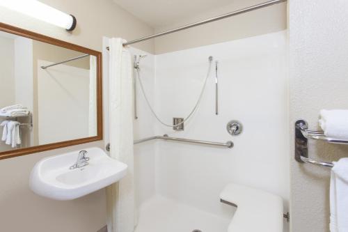 a bathroom with a sink and a mirror at Days Inn by Wyndham Carlsbad in Carlsbad