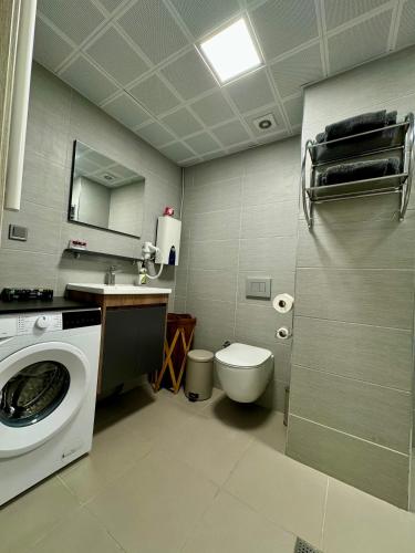 a bathroom with a washing machine and a toilet at Royal Kate SPA included, 32nd floor in Skopje