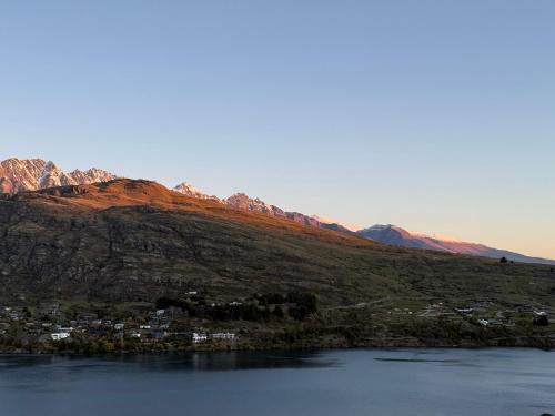 a town on a hill next to a body of water at Goldrush #1 in Queenstown