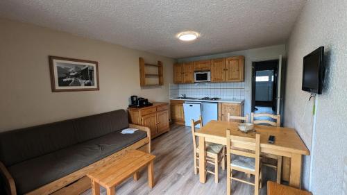 un salon avec un canapé et une table et une cuisine dans l'établissement Résidence Meijotel - Studio résidence Meijotel MAE-9291, à Vénosc