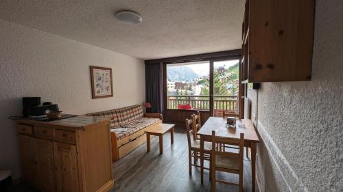 un salon avec un canapé et une table avec des chaises dans l'établissement Résidence Meijotel - Studio résidence Meijotel MAE-9381, à Vénosc