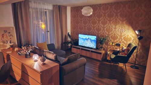 Una sala de estar con un sofá y un televisor. en FREE PARKING & Self Check-IN WestSide Studio Near the Lake, Lacul Morii,Near Metro Stations Sector6, en Bucarest