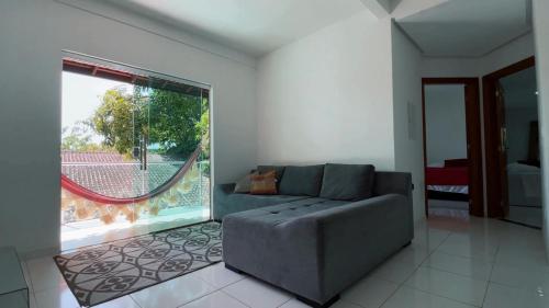 a living room with a couch and a large window at Alter do Chão Casa de praia nobre beira mar in Alter do Chao