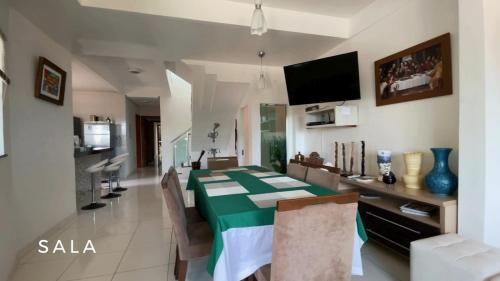 a dining room with a green table and chairs at Alter do Chão Casa de praia nobre beira mar in Alter do Chao
