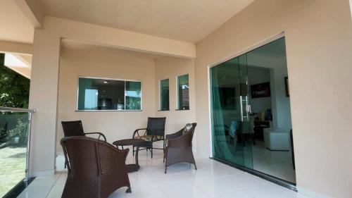 a patio with chairs and a table and glass doors at Alter do Chão Casa de praia nobre beira mar in Alter do Chao
