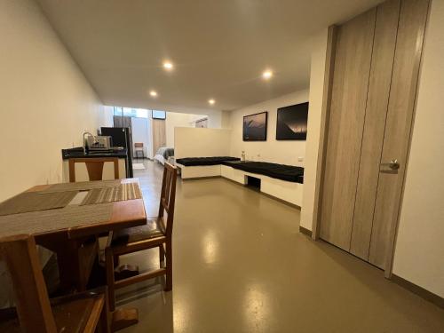 a room with a table and a room with a bed at Ope Suites calle 100 in Bogotá