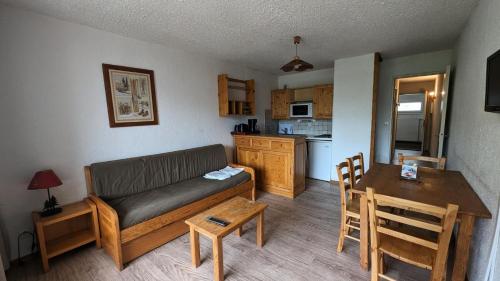 un salon avec un canapé et une table et une cuisine dans l'établissement Résidence Meijotel - Studio résidence Meijotel MAE-9511, à Vénosc