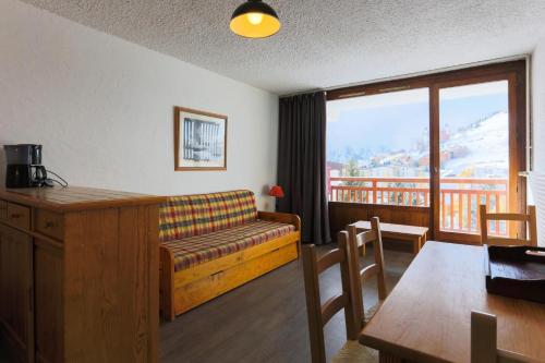 d'un salon avec un canapé et une table ainsi que d'un balcon. dans l'établissement Résidence Meijotel - Studio résidence Meijotel MAE-9621, à Vénosc