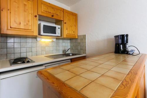 - une cuisine avec un comptoir et un four micro-ondes dans l'établissement Résidence Meijotel - Studio résidence Meijotel MAE-9621, à Vénosc