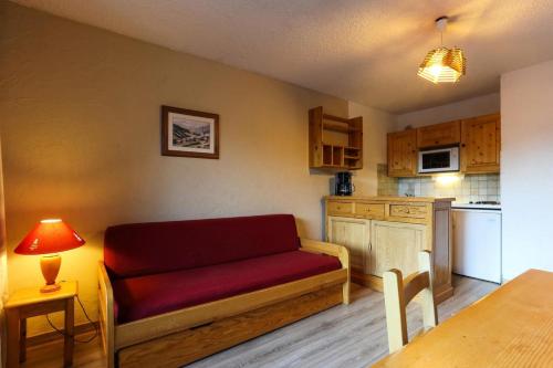 un salon avec un canapé rouge dans une cuisine dans l'établissement Résidence Meijotel - Studio résidence Meijotel MAE-9631, à Vénosc