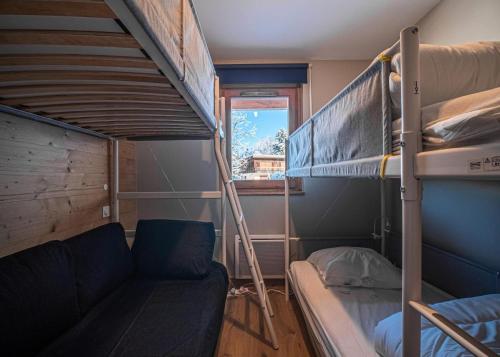 Cette petite chambre comprend un canapé et des lits superposés. dans l'établissement Résidence Lumi Batiment A - LUMI A 304 MAE-9051, à Valmorel