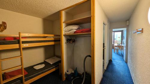 Cette petite chambre comprend des lits superposés et un couloir. dans l'établissement Résidence Meijotel - Studio résidence Meijotel MAE-9751, à Vénosc