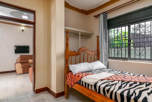 a bedroom with a bed and a window at Rendy partment- KAWUKU in Kisubi