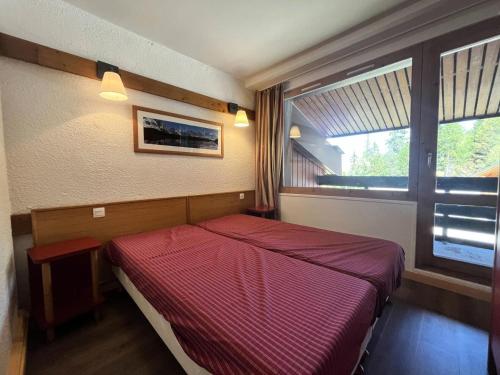 - une chambre avec un lit rouge et une fenêtre dans l'établissement Résidence Doronic - Résidence DORONIC N°871 MAE-1491, à La Plagne Tarentaise