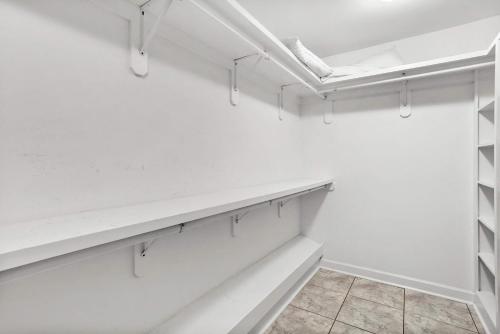 a white walk in closet with white shelves at Endless Summer Retreat with Private Pool near Beach in Gautier