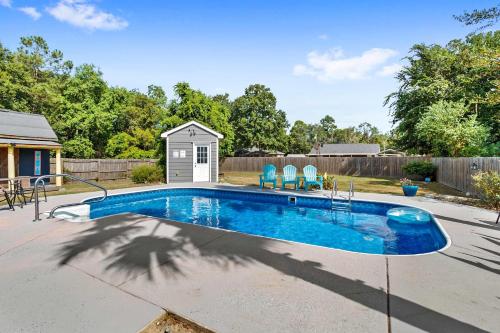 a swimming pool with blue chairs in a yard at Endless Summer Retreat with Private Pool near Beach in Gautier