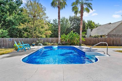 a small swimming pool in a yard with a fence and palm trees at Endless Summer Retreat with Private Pool near Beach in Gautier