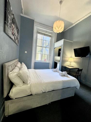 a bedroom with a large white bed with a window at Kensington Gardens in London
