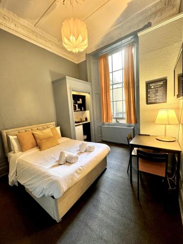 a bedroom with a bed and a table and a desk at Kensington Gardens in London