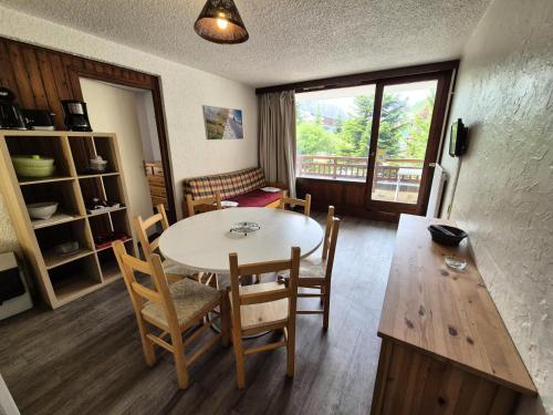 une salle à manger avec une table et des chaises et une fenêtre dans l'établissement Résidence Meijotel - Studio résidence Meijotel MAE-9471, à Vénosc