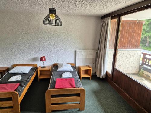 une chambre avec deux lits et une fenêtre dans l'établissement Résidence Meijotel - Studio résidence Meijotel MAE-9471, à Vénosc