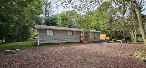 a small house in the middle of a yard at Aria Pocono Home in Tobyhanna