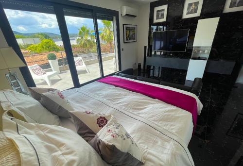 un lit dans une chambre avec une grande fenêtre dans l'établissement Villa Medusa, du confort à proximité des plages et de Montpellier, à Vic-la-Gardiole