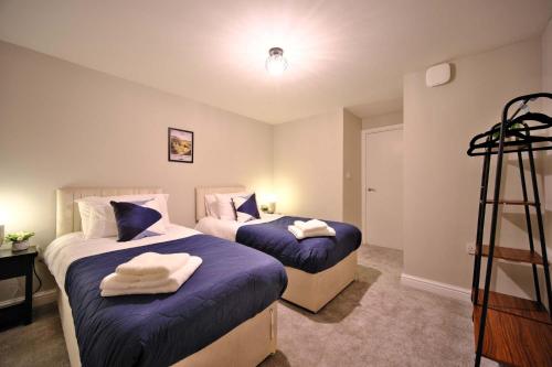 a bedroom with two beds with towels on them at 1 bedroom, 3 beds, M1, M62, Wi-Fi, Free Parking in Dewsbury