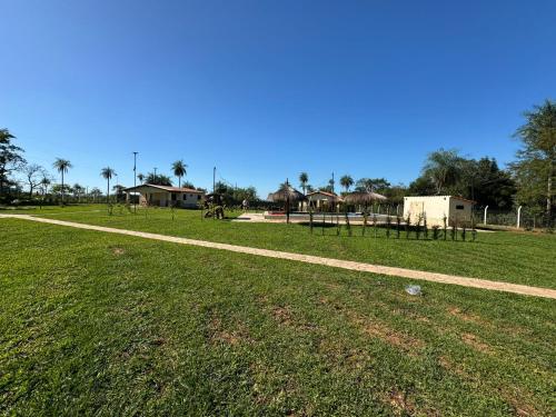a path in a field with a park with picnic tables at Residencia Piri in Piribebuy