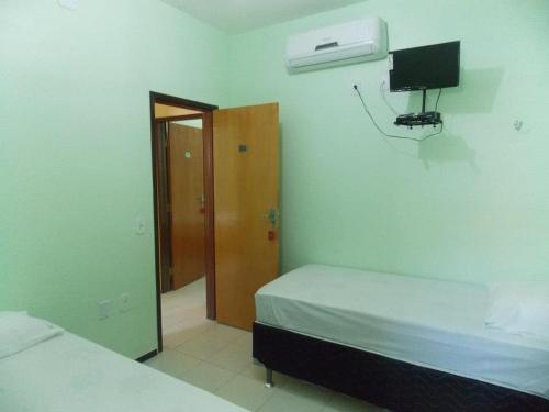 1 dormitorio con 1 cama y un aro de baloncesto en la pared en Pousada Cariri en Juazeiro do Norte