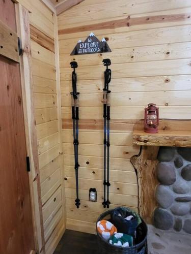 a wooden cabin with a sign on the wall at Knotty Shack- Unique Tiny Log Cabin with Hot Tub in Ashford