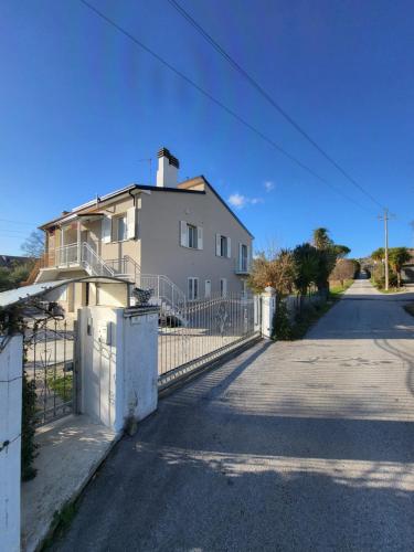a white house with a fence in front of it at Casa degli Ulivi - Apartment A in Porto San Giorgio