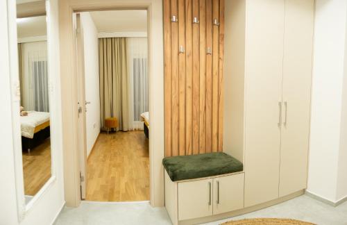 a dressing room with white cabinets and a green ottoman at Apartament ZHana in Podgorica